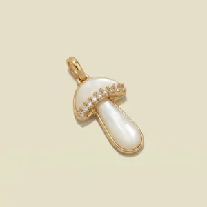Gedetailleerde macro-opname van een gouden paddenstoelhanger met wit parelmoer inleg en kristallen