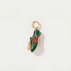 Détail d'un pendentif chausson de ballet vert foncé avec gland doré et motif d'aile