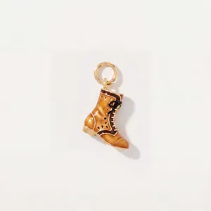 Gros plan d'un pendentif bottine marron vintage avec anneau doré à l'or 18K