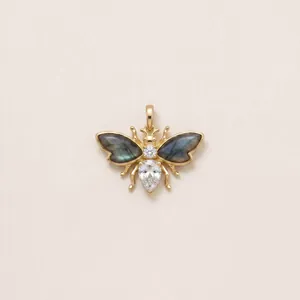 Detailed view of a gold bee pendant with labradonite wings and white crystals.