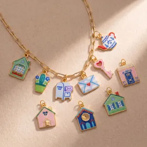 Close-up of garden style charms including cactus, house, and teapot on a gold chain