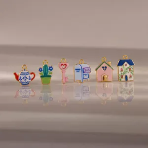 Set of six colorful pastoral enamel charms including teapot, cactus, and cottage designs.