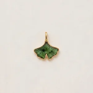 Detailed macro view of an 18K gold plated ginkgo leaf pendant with green enamel inlay