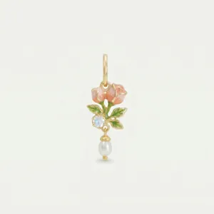 Detailed macro shot of a gold flower pendant with pink enamel roses and a pearl drop