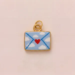 Macro view showing the heart and cloud pattern on a gold-plated envelope pendant
