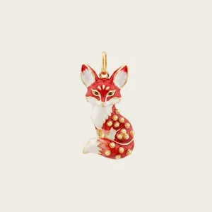 Vue détaillée d'un élégant pendentif renard en émail rouge et blanc avec touches dorées