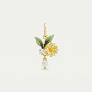 Detail view of a gold floral pendant featuring enamel daisy, green leaves, and a pearl drop.