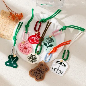A variety of colorful acrylic bag charms featuring bear, lotus, and floral designs
