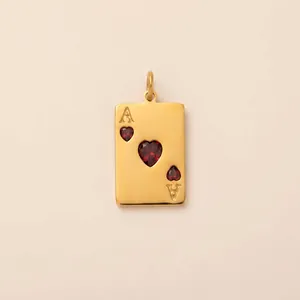 Macro detail of a 18K gold plated Ace of Hearts poker card pendant with red heart gems.