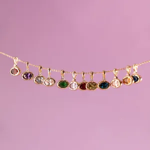 Detail view of colorful gemstone pendants on an 18K gold-plated stainless steel chain.