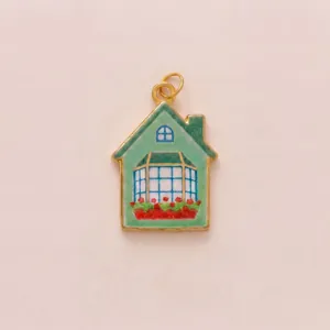 Detailed view of pastoral style house pendant with green glitter enamel and red flowers