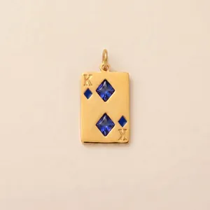 Detailed close-up of a gold-plated stainless steel King of Diamonds pendant with blue stones.