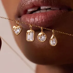 Gros plan de pendentifs gouttes plaqués or 18 carats avec cristaux sur une chaîne.