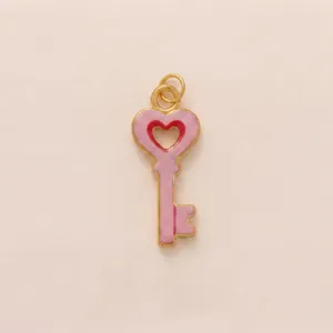 Detailed view of a pink heart-shaped key pendant with gold-toned metal edges.