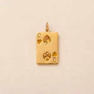 Detail of a golden Queen poker card pendant with heart-shaped yellow gemstones