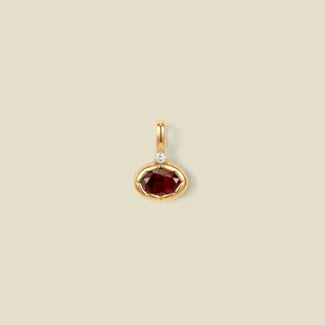Close-up of elegant oval ruby pendant with 18K gold plating and small sparkling accent stone