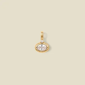 Macro view of oval clear crystal pendant in 18K gold plated frame with small diamond
