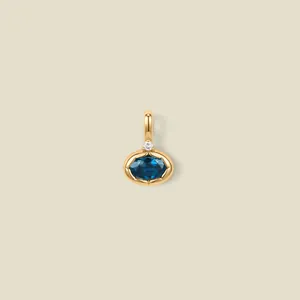 Detailed view of an oval blue gemstone pendant set in 18K gold plated stainless steel