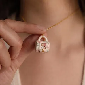 Detailed close-up of a healing miniature scene ceramic pendant necklace in a mug shape