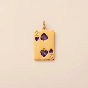 Detail of 18K gold-plated playing card pendant with purple spade-shaped gems.