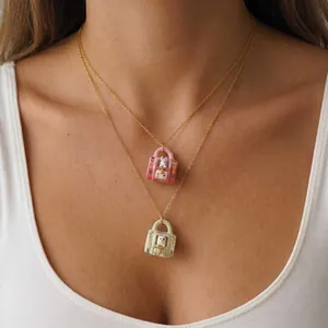 Detail view of miniature rabbit and cat ceramic pendant necklaces on a gold chain