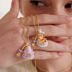 Detailed macro view of openable rabbit cake pendants in pastel enamel and gold finish