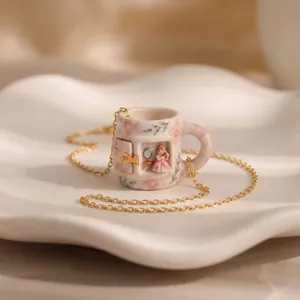 Close-up of miniature princess scene inside floral ceramic mug pendant necklace