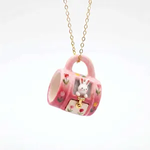 Detailed macro view of a cute pink ceramic mug pendant necklace featuring a white rabbit