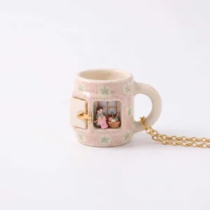 Exquisite detail of the knitting girl miniature scene inside a ceramic mug pendant necklace.