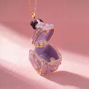 Detailed macro view of openable purple suitcase necklace with a cute cat inside