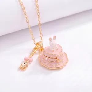 Detail view of heart-shaped rabbit cake necklace with pink bow spoon charm detail