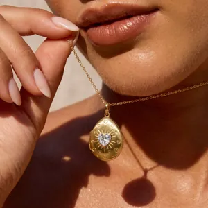 Detailansicht eines goldenen Tropfen-Medaillons mit einem eingesetzten Herzkristall