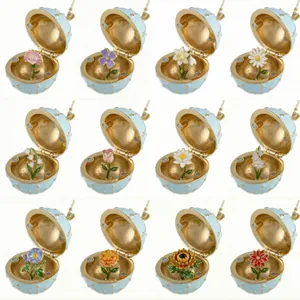 Collection of 12 distinct enamel birth flower styles inside round gold-plated locket boxes