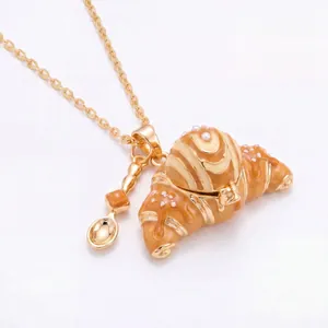 Nahaufnahme einer verspielten goldenen Croissant-Medaillon-Halskette mit Perlenbesatz