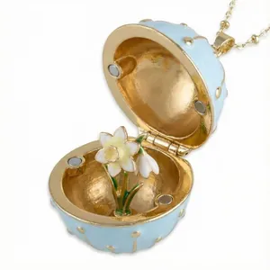 Detail view of an open blue enamel egg pendant necklace showing a delicate flower inside