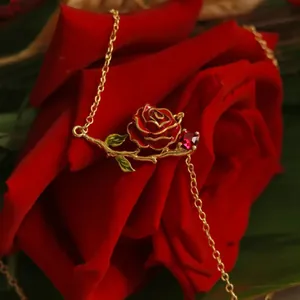 Macro view of vintage red rose enamel necklace with ruby-colored gemstone
