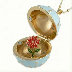 Close-up of golden circular opening necklace with detailed red enamel flower inside