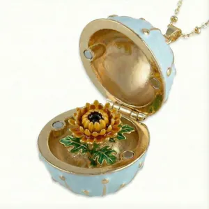 Detailed view of openable egg pendant with sunflower inside in gold plated finish