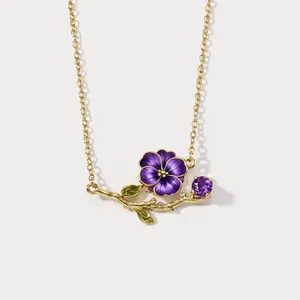 Detailed view of a retro purple enamel flower necklace with golden branch and gemstone