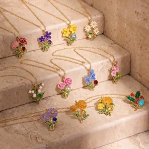 Twelve months birth flower enamel necklaces with gems displayed on stone steps display