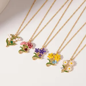 Close-up view of five vibrant enamel birth flower necklaces with gold chains and crystals