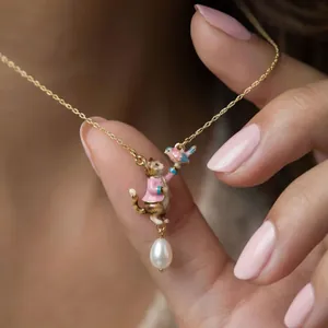 Whimsical fairytale cat and bird pendant necklace featuring a delicate pearl drop