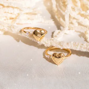 Vista detallada de anillos abiertos de relicario de corazón bañados en oro con circón