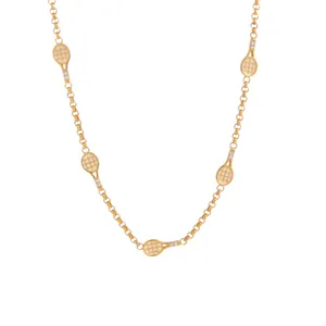 Détail d'un collier chaîne doré avec plusieurs pendentifs raquettes de tennis et cristaux.
