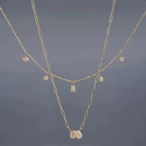 Detail view of gold layered necklace set with geometric pendants and paperclip chain