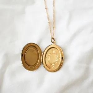 Eleganter 14k Gold Vintage Medaillon Anhänger mit zarter Kugelchenkette auf weißem Stoff