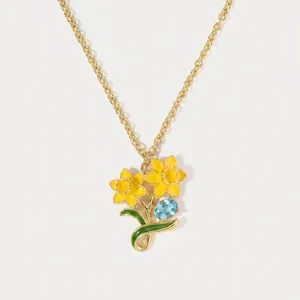 Detailed macro shot showing the enamel daffodil pendant and light blue oval gemstone