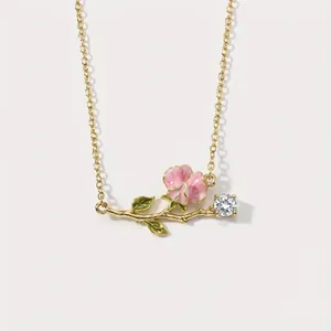 Vintage gold-tone necklace featuring pink enamel flower and sparkling gemstone pendant