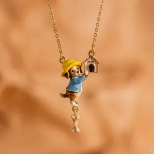 Detail view of a fairytale style enamel dog pendant necklace with a tiny doghouse and bone