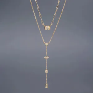 Close-up of layered Y-shaped necklace and paperclip chain with baguette diamond